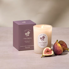 Thymes candle with packaging and figs on a neutral background