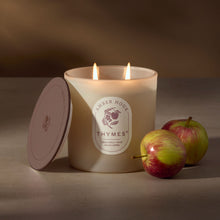 Thymes candle with two apples on a neutral background