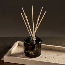 Black diffuser with wooden sticks on a stone surface