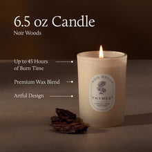 Thymes candle with label and pine cones on a dark background