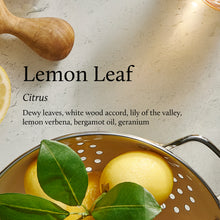 Lemons with leaves in a colander on a textured surface with text 'Lemon Leaf Citrus'.