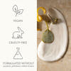 Blot of lotion with decorative elements on a beige surface, featuring vegan and cruelty-free icons.