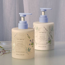 Two Thymes lavender body wash and body lotion bottles on a neutral background