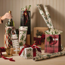 Multiple presents wrapped in Fraiser Fir Tissue Paper, Gift Tags and Wrapping Paper on a table.