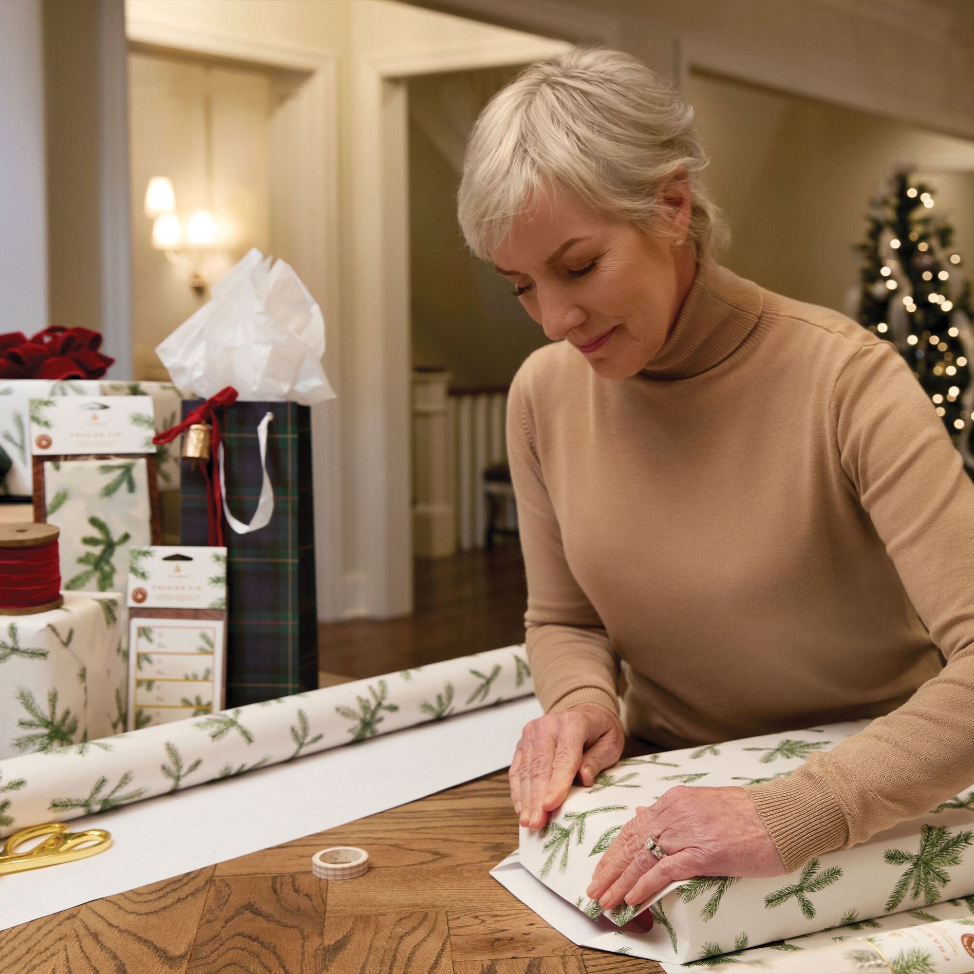 Gift being wrapped with Thymes Frasier Fir Fragranced Wrapping Paper