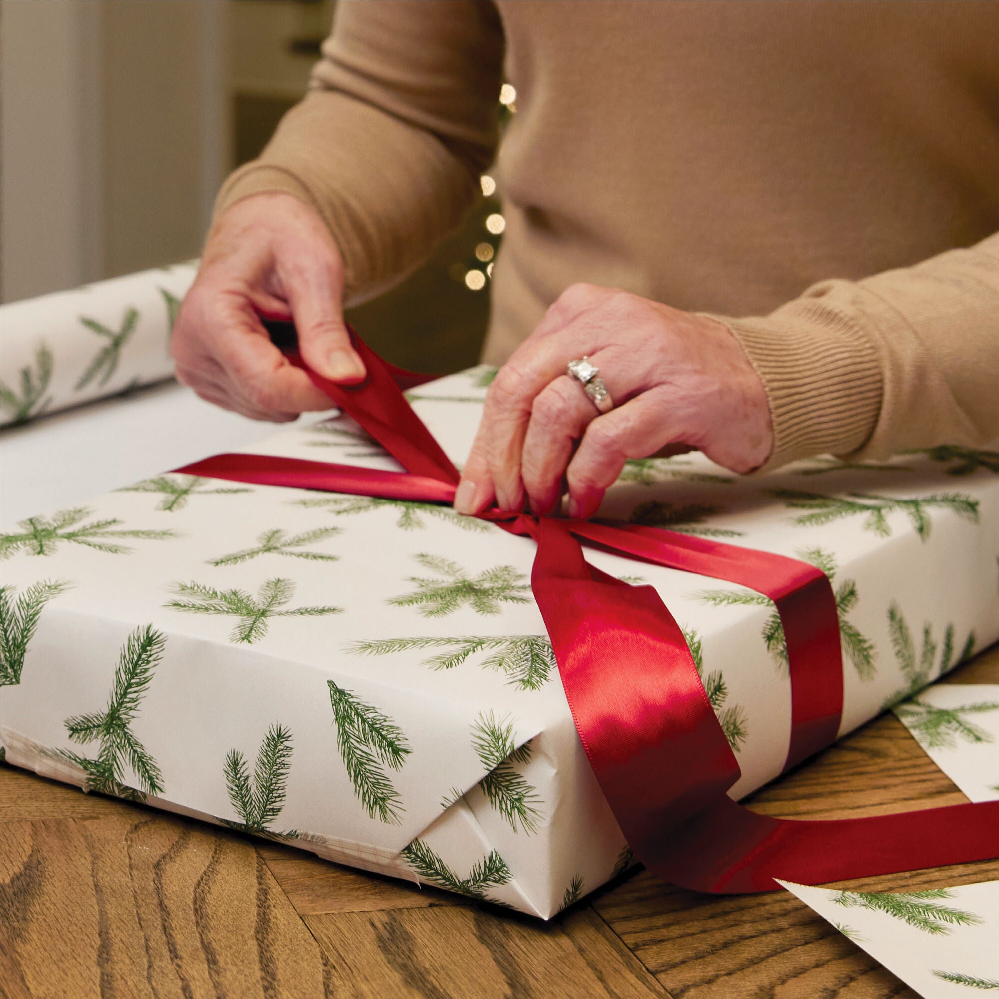 Gift being wrapped with Thymes Frasier Fir Fragranced Wrapping Paper