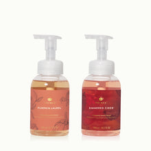 Two bottles of Thymes hand wash, one labeled 'Pumpkin Laurel' and the other 'Simmered Cider', on a white background.