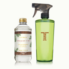 Thymes Frasier Fir diffuser refill bottle and green spray bottle on a white background