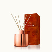 Copper diffuser with wooden sticks and packaging labeled 'Simmered Cider' on a white background