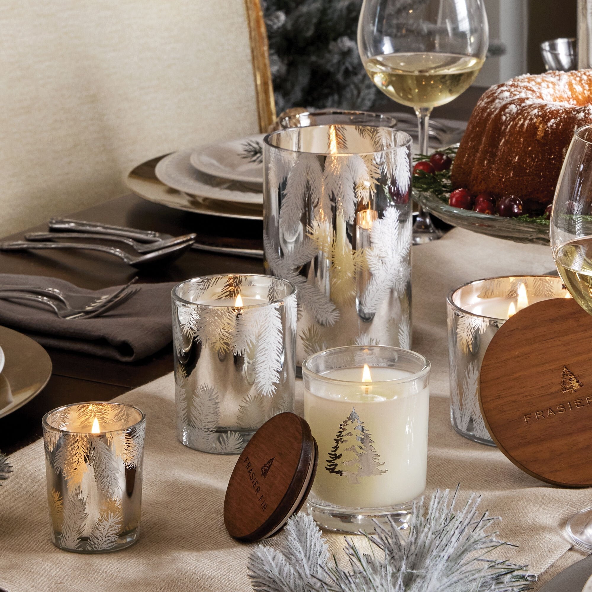 An assortment of Thymes Frasier Fir candles on a dining table