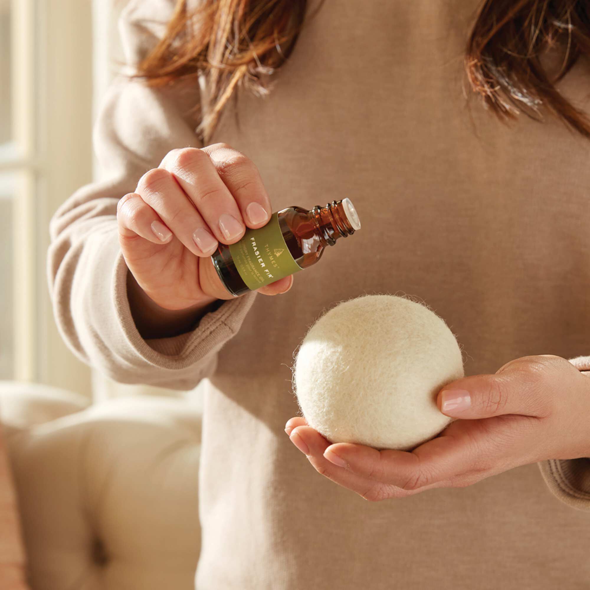 Laundry fragrance oil being applied to a wool dryer ball