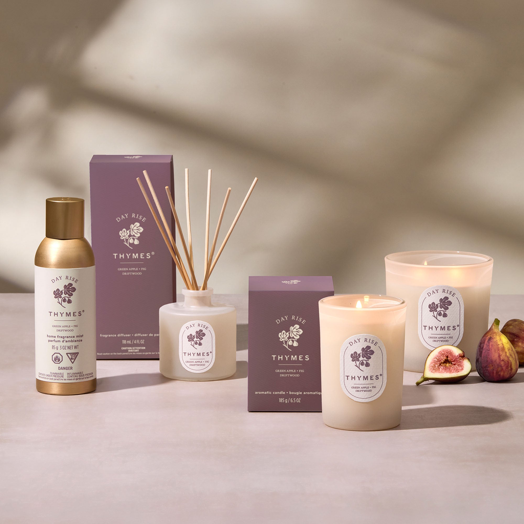 Thymes product line including candles, diffuser, and boxes on a neutral background