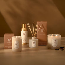 Thymes product set including candles, diffuser, and boxes on a brown background