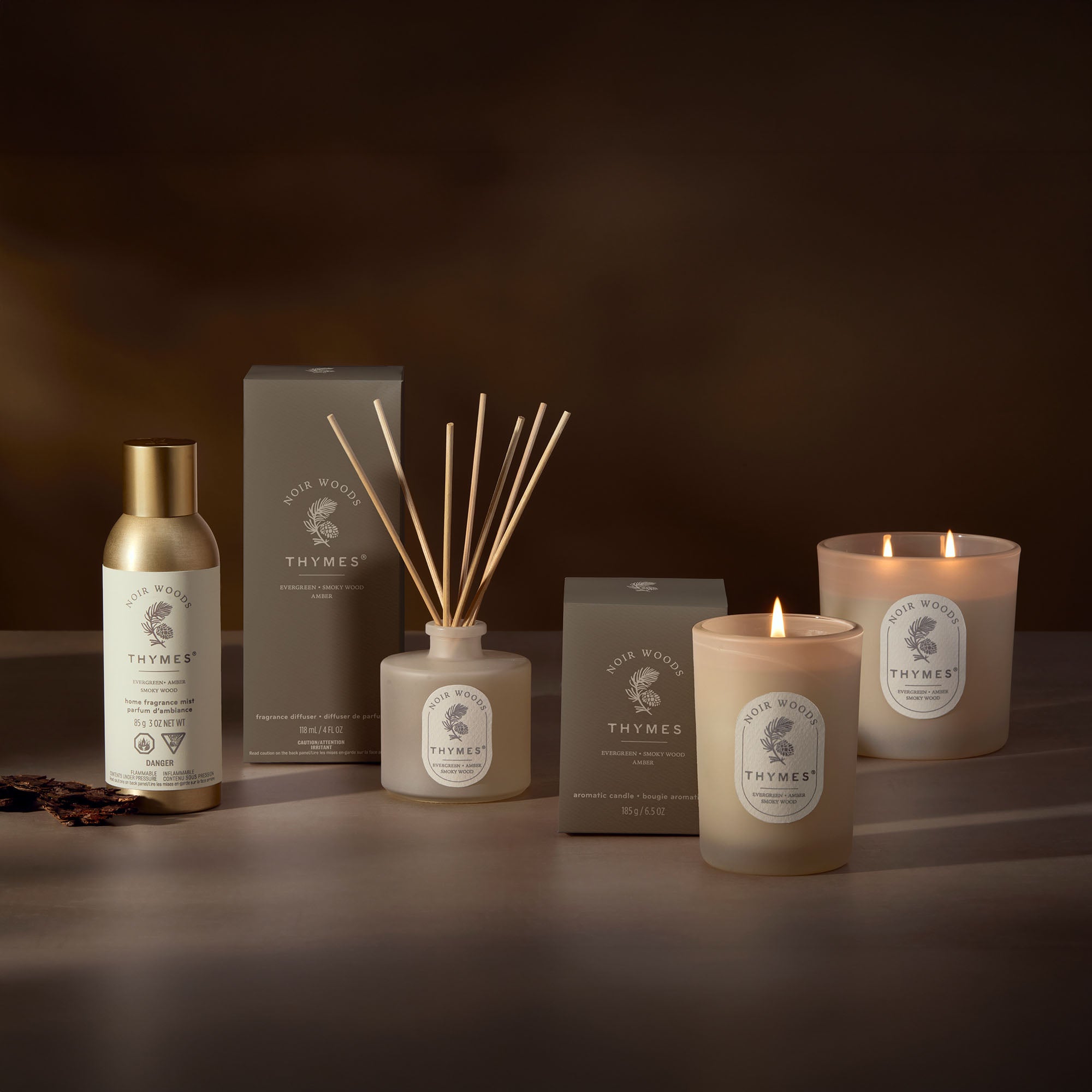 Thymes product line including candles, diffuser, and bottle on a dark background