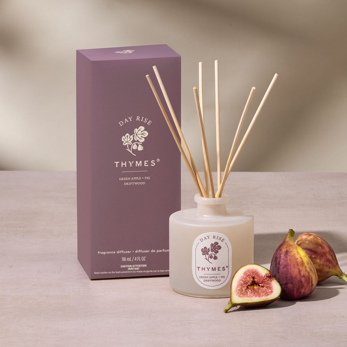 Alternate image of Thymes fragrance diffuser with packaging and figs on a neutral background