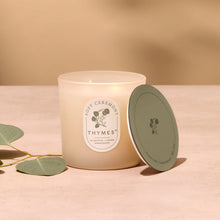Thymes candle with a green lid on a beige background