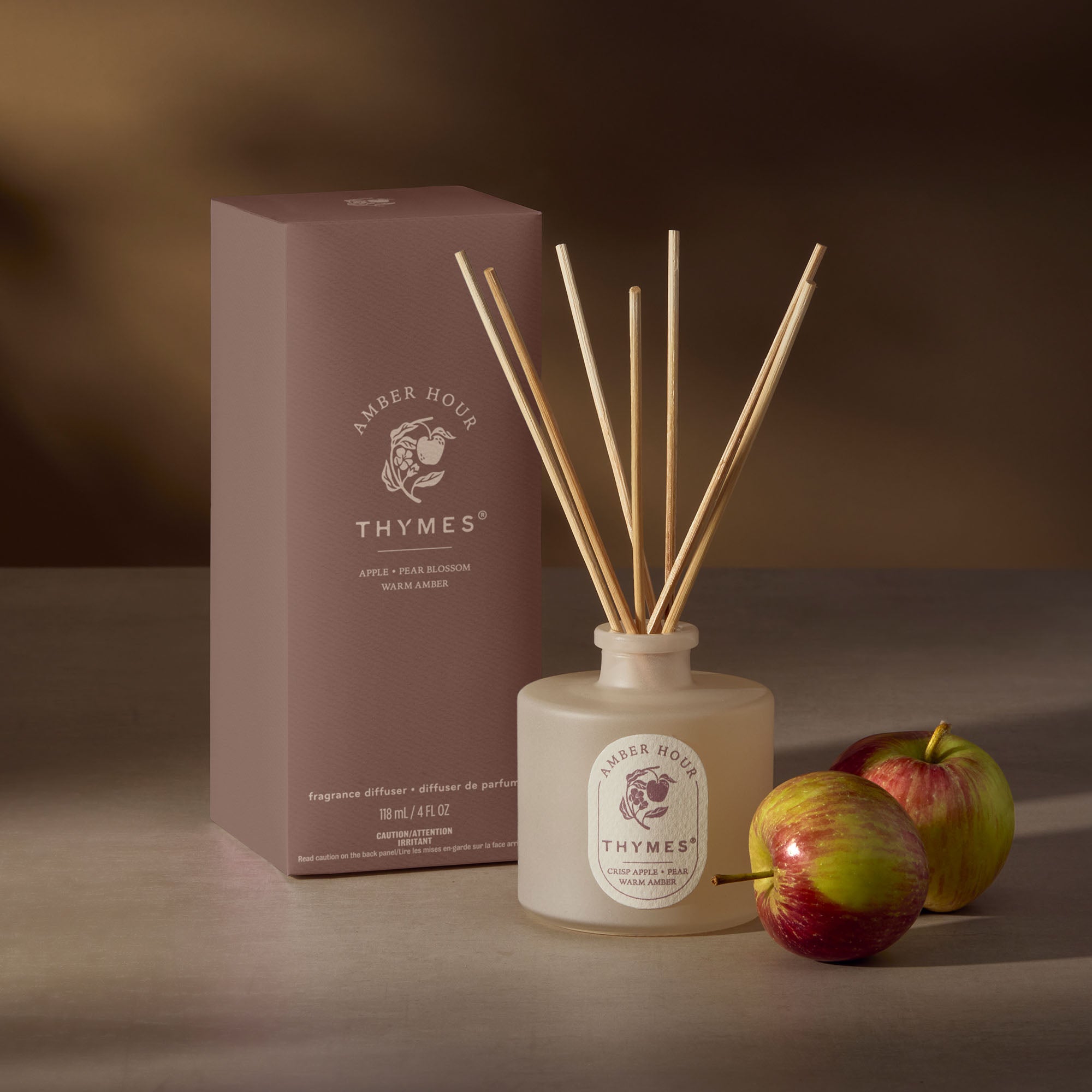 Thymes diffuser with packaging and apples on a neutral background