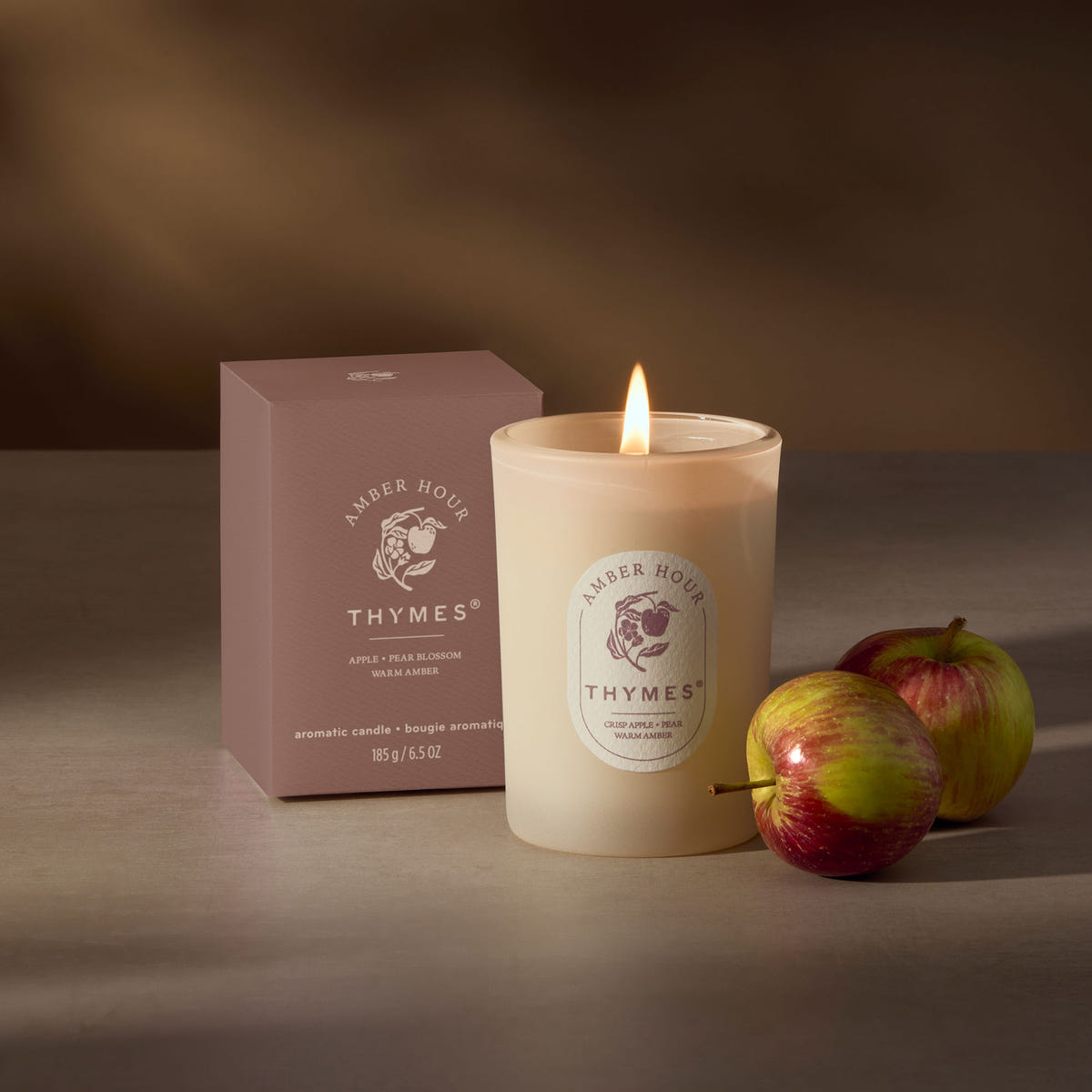 Alternate image of Thymes candle with apples on a dark background