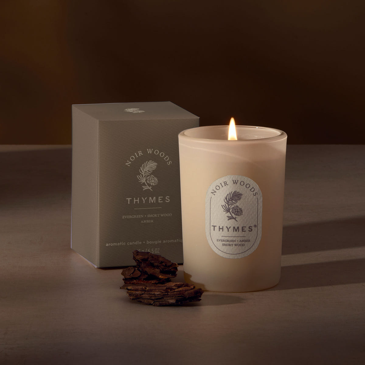 Alternate image of Thymes candle with packaging on a dark background