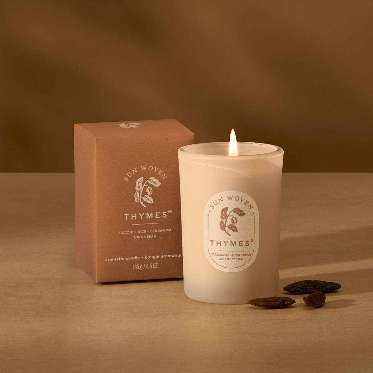 Alternate image of Thymes candle and packaging on a brown background