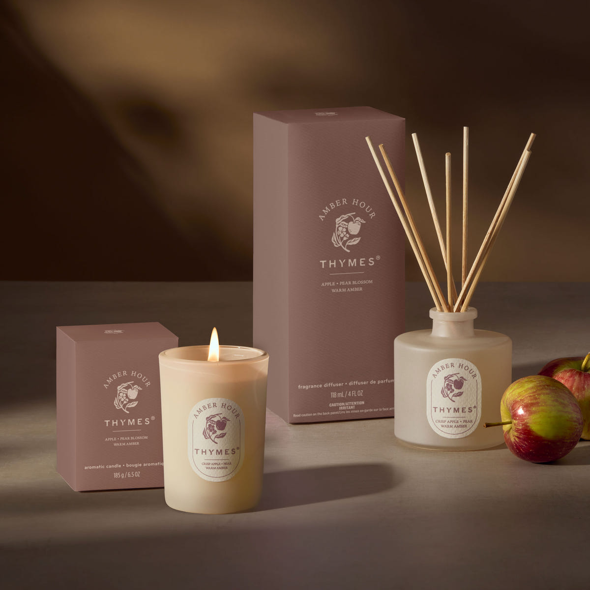 Alternate image of Thymes candle, diffuser, and packaging on a dark background