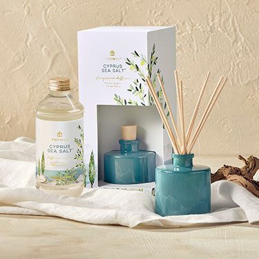 Cypress sea salt product with diffuser and packaging on a neutral background
