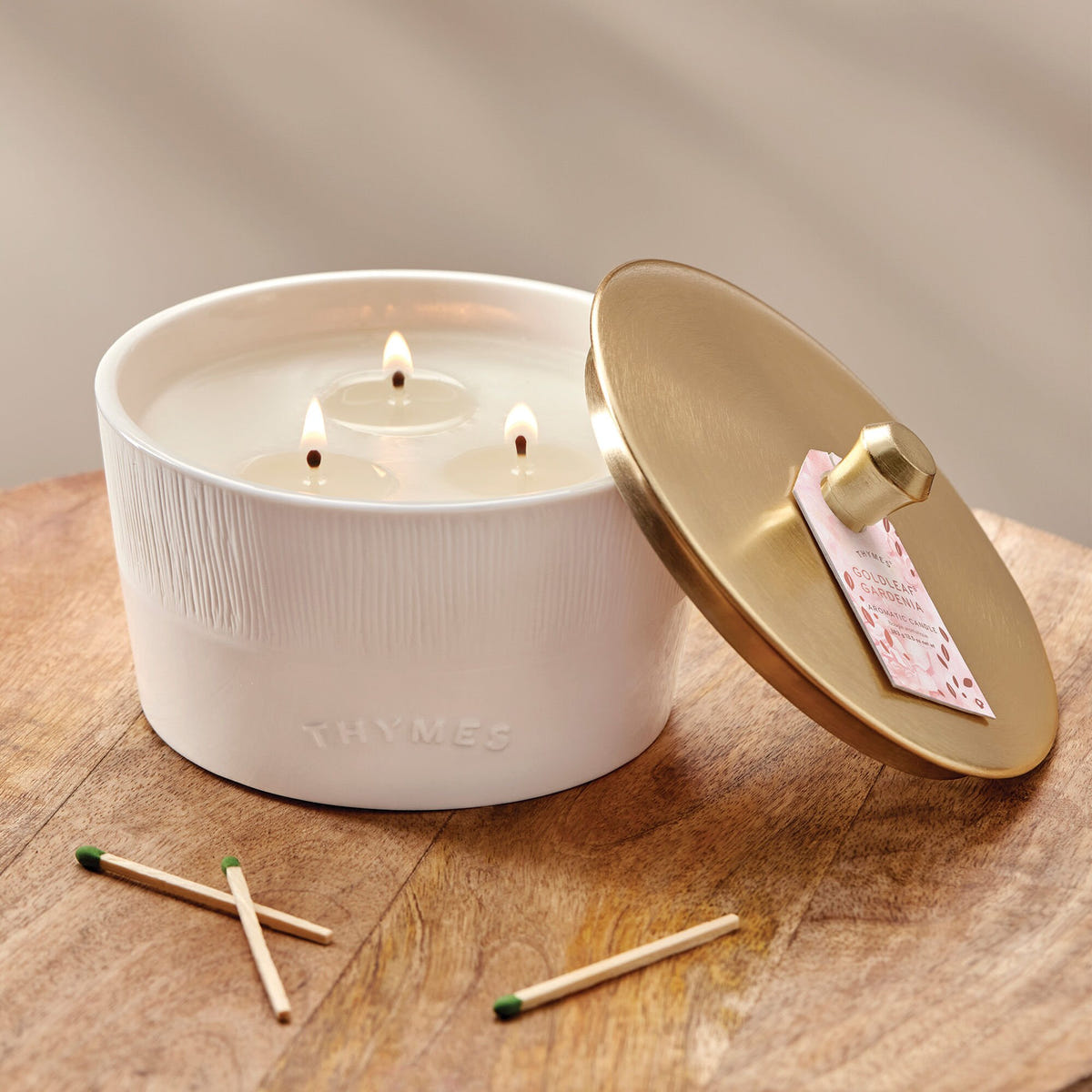 Alternate image of Thymes Goldleaf Gardenia 3-Wick Candle on table