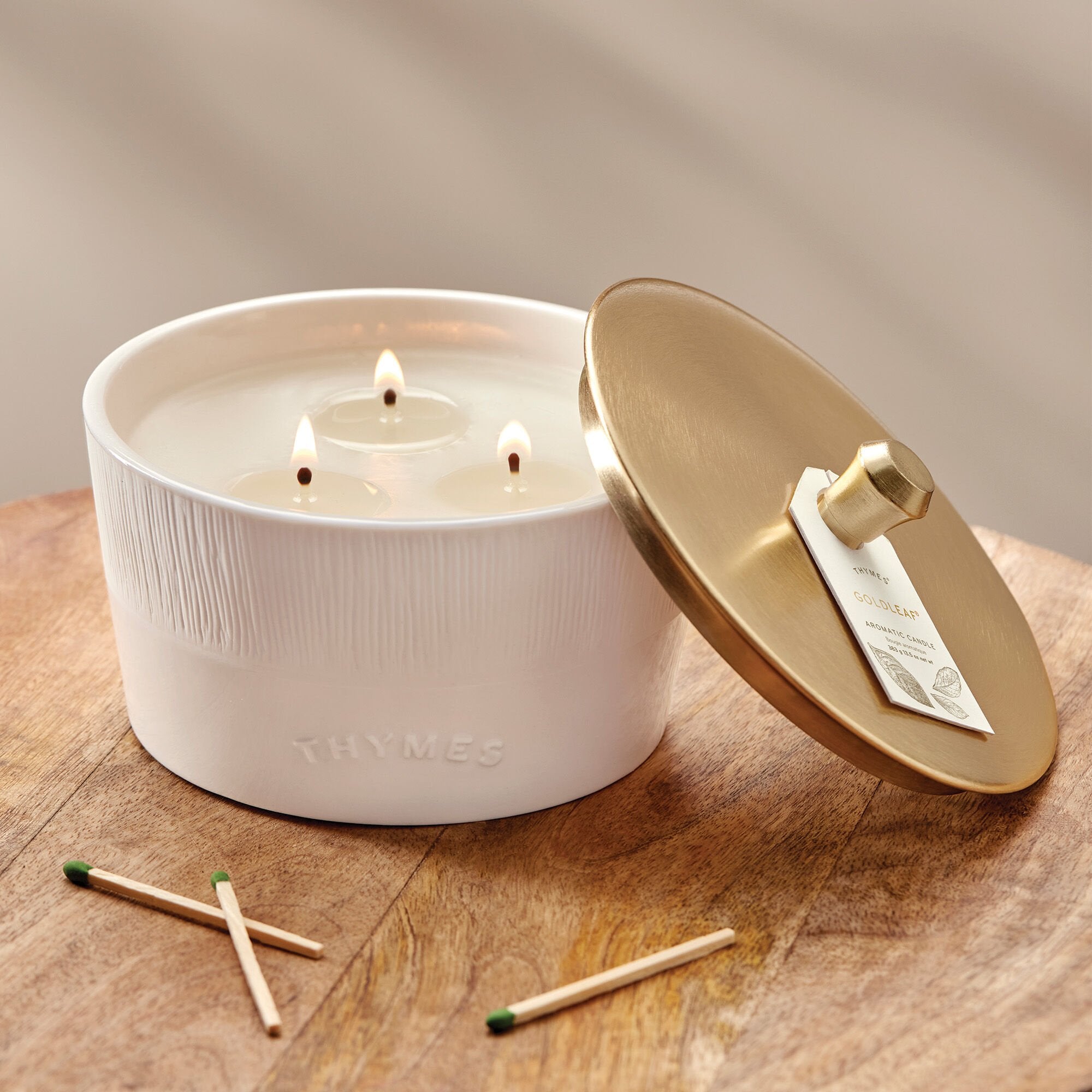 Thymes Goldleaf 3-Wick Candle on table