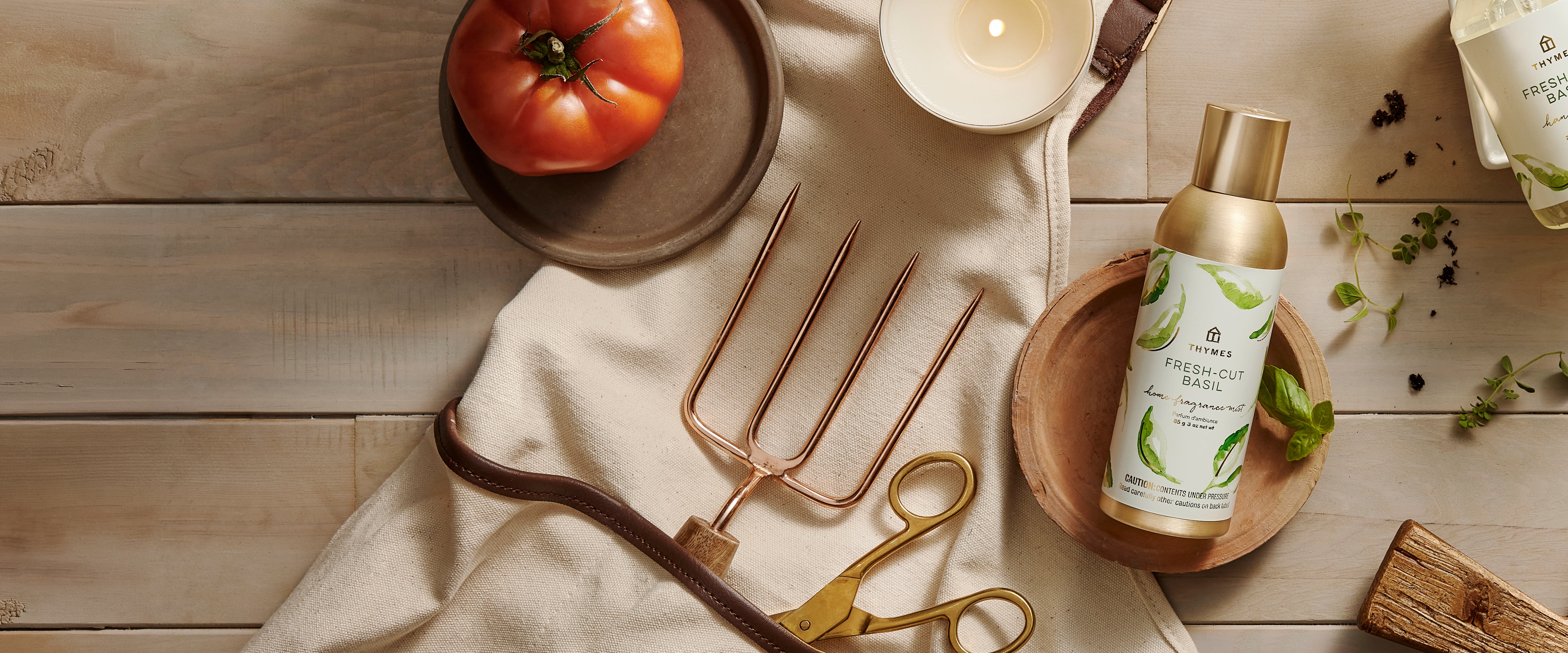 Product on a wooden surface with a candle, tomato, and decorative fork.