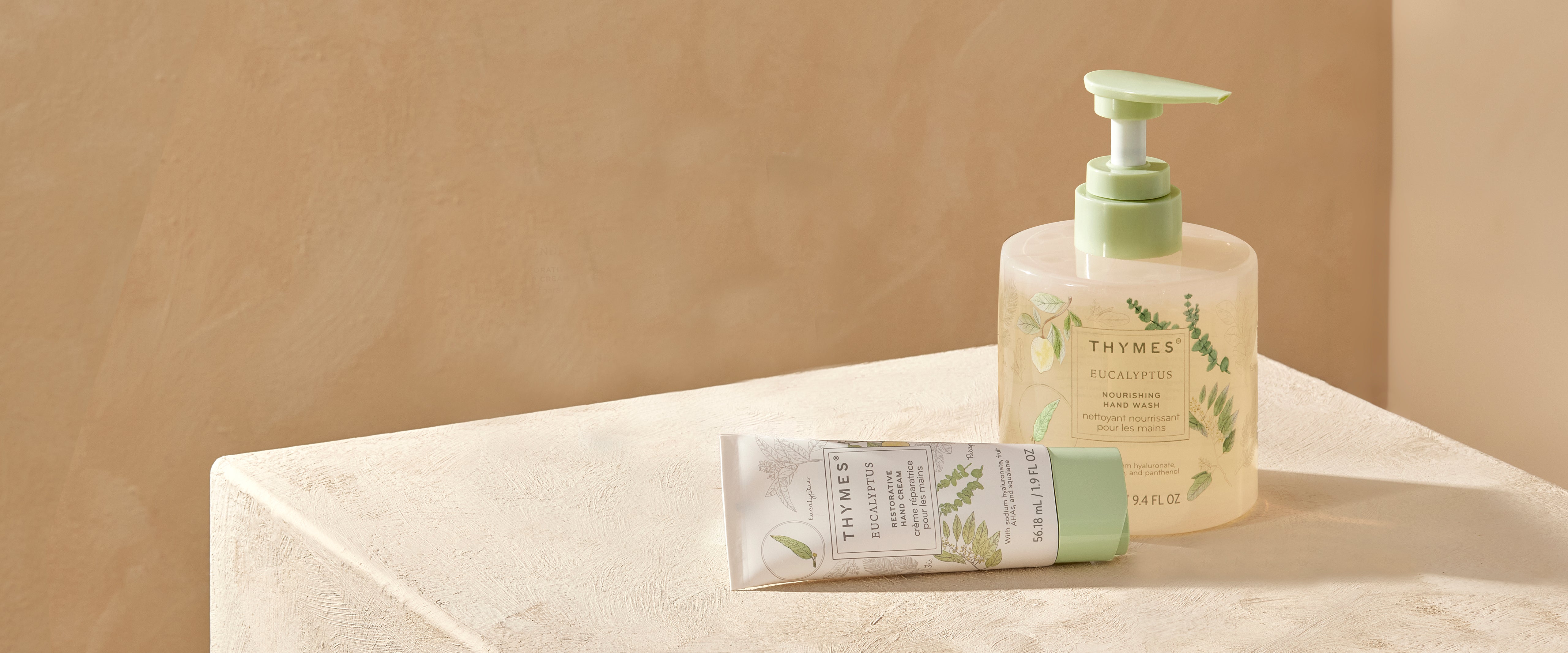 Lotion bottle and tube on a beige surface with a neutral background
