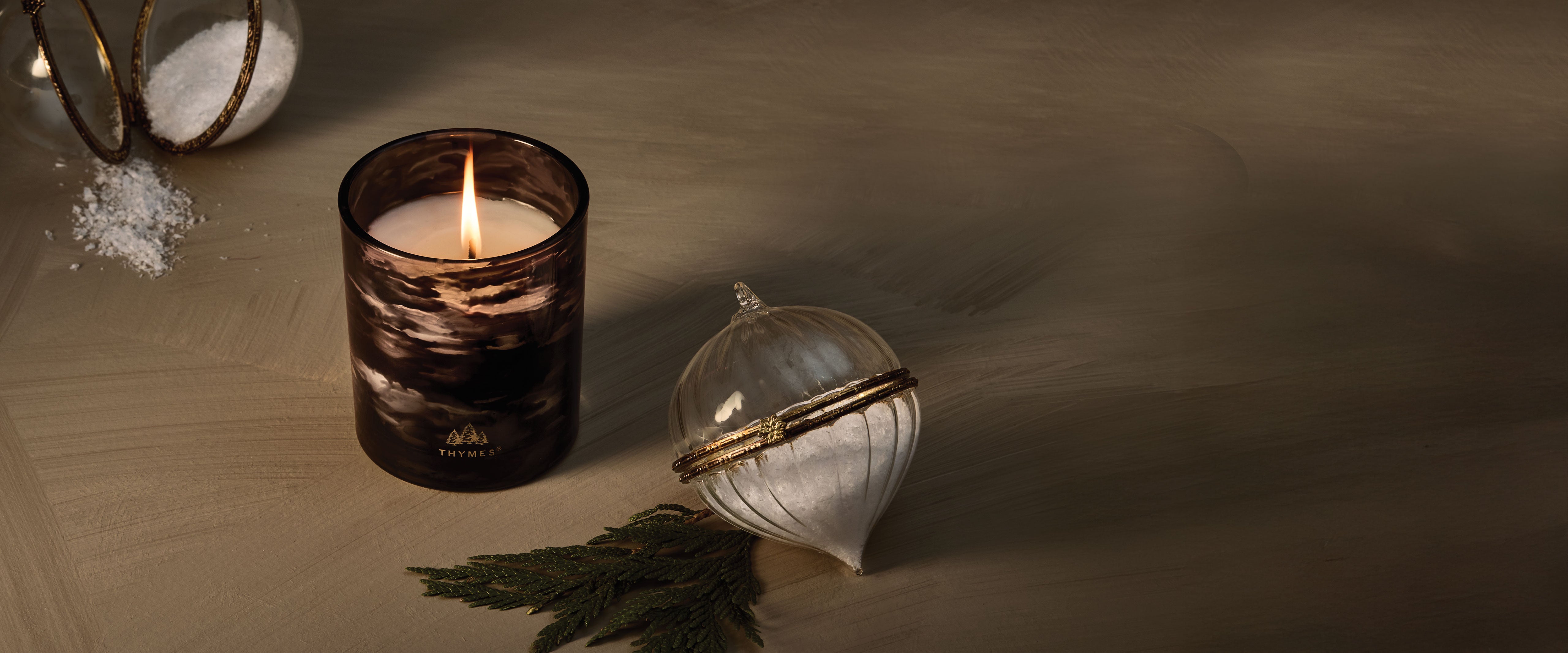 Noir Woods candle with an ornament on a blurred background