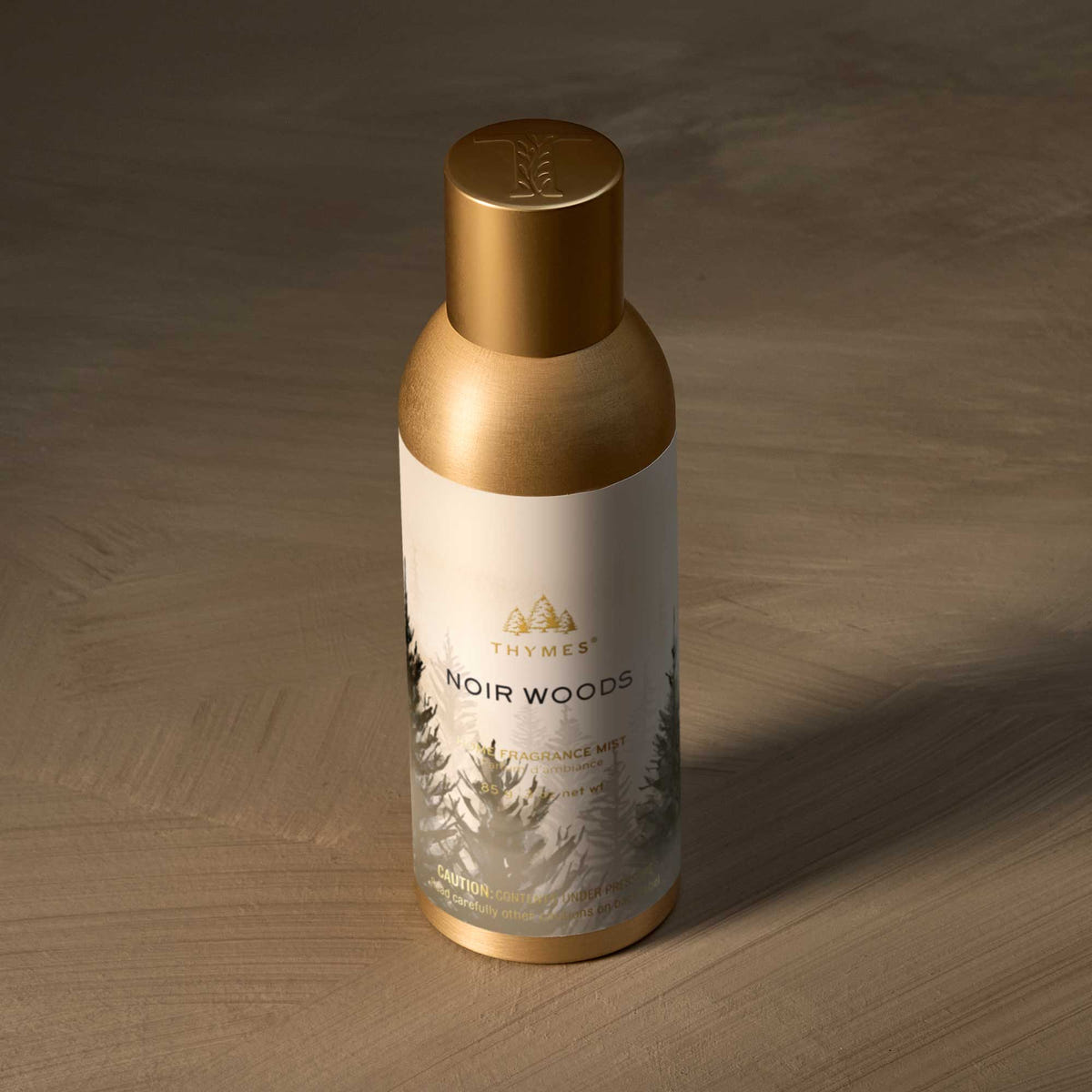 Alternate image of Thymes Noir Woods room fragrance mist on a wooden surface
