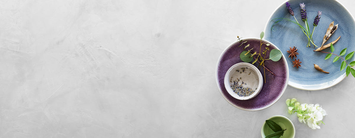 Bowl of various botanical elements on a marble surface