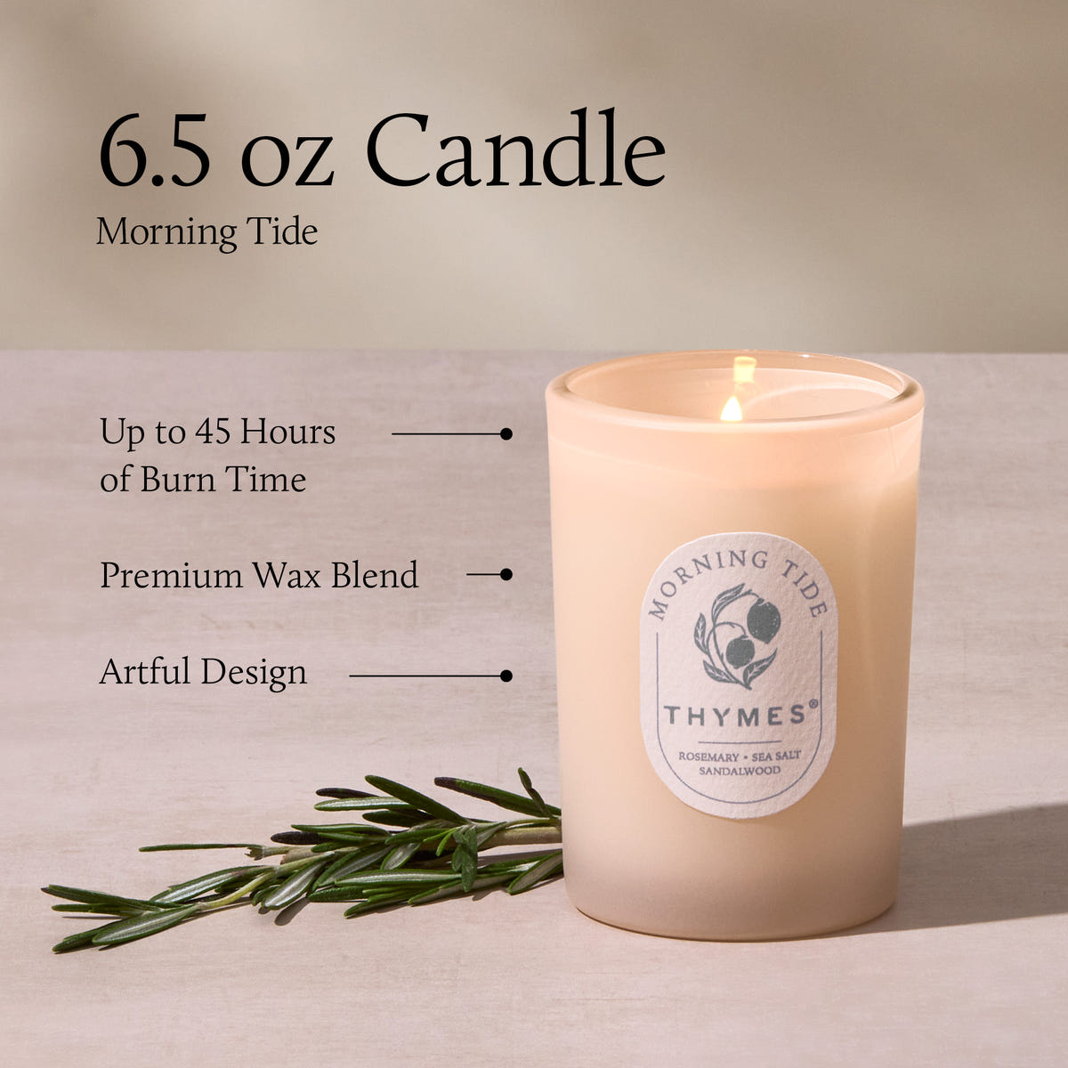 Thymes candle with label and greenery on a neutral background