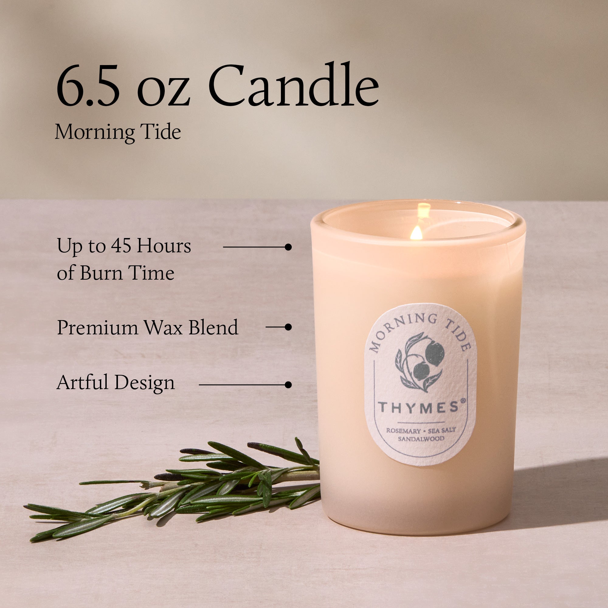 Thymes candle with label and greenery on a neutral background
