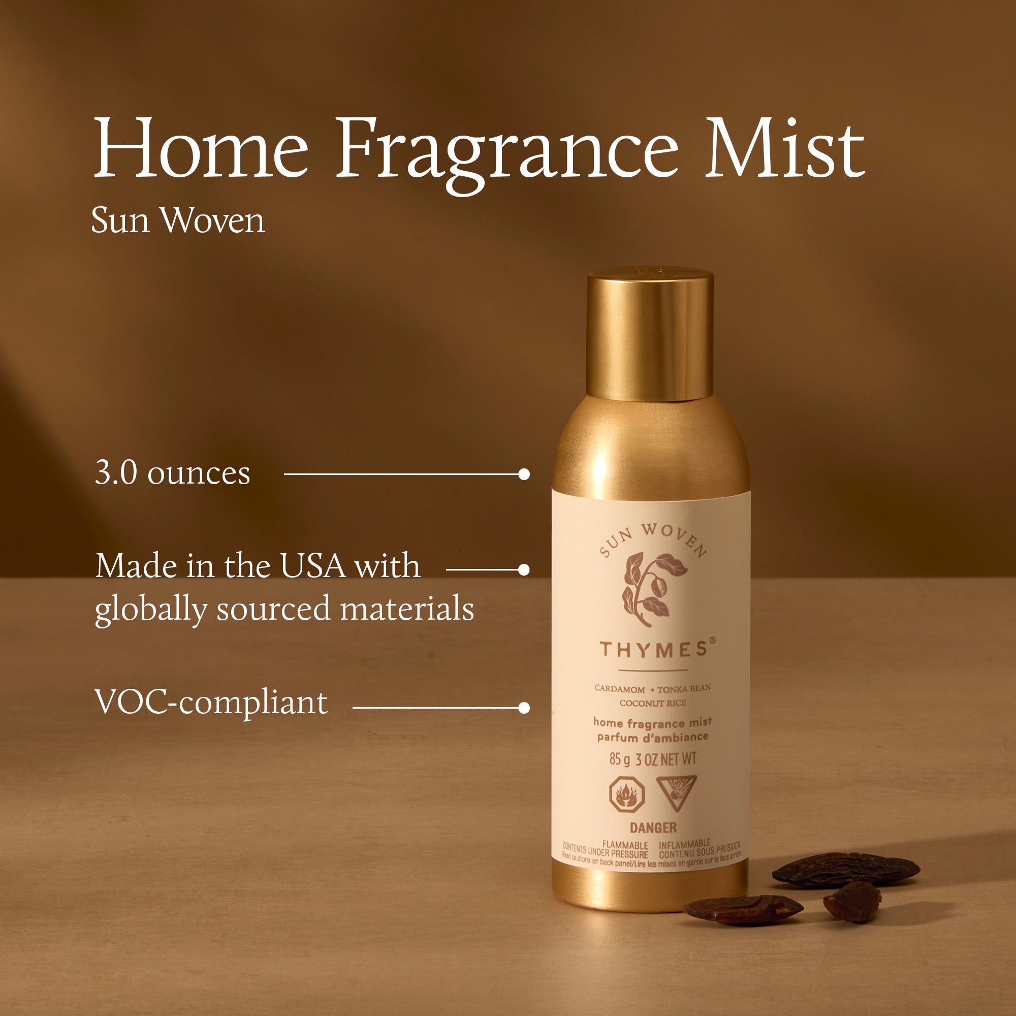Gold bottle of Thymes Home Fragrance Mist on a brown background