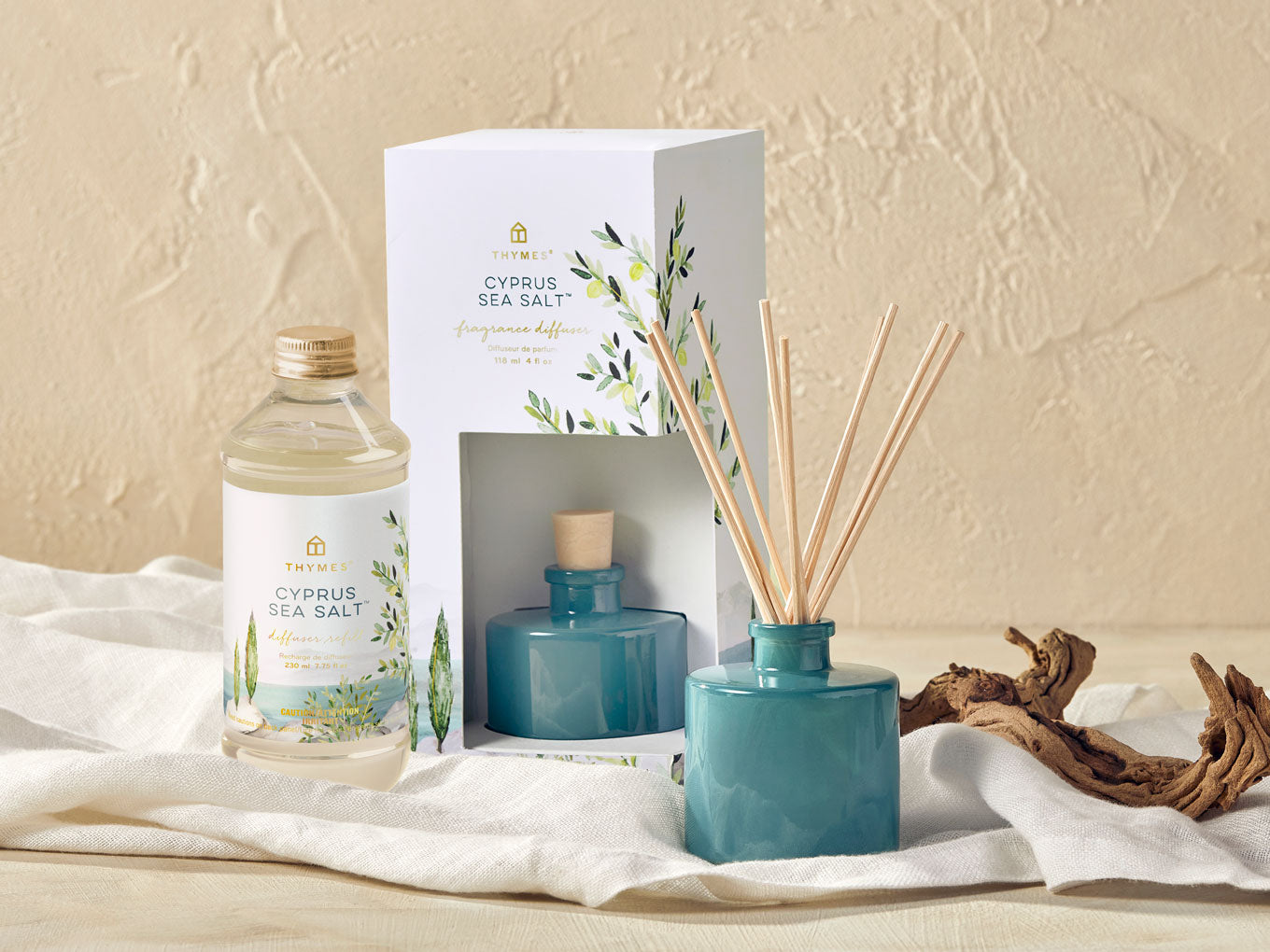 Teal diffuser with reeds, bottle of Cypress Sea Salt, and packaging on a beige background