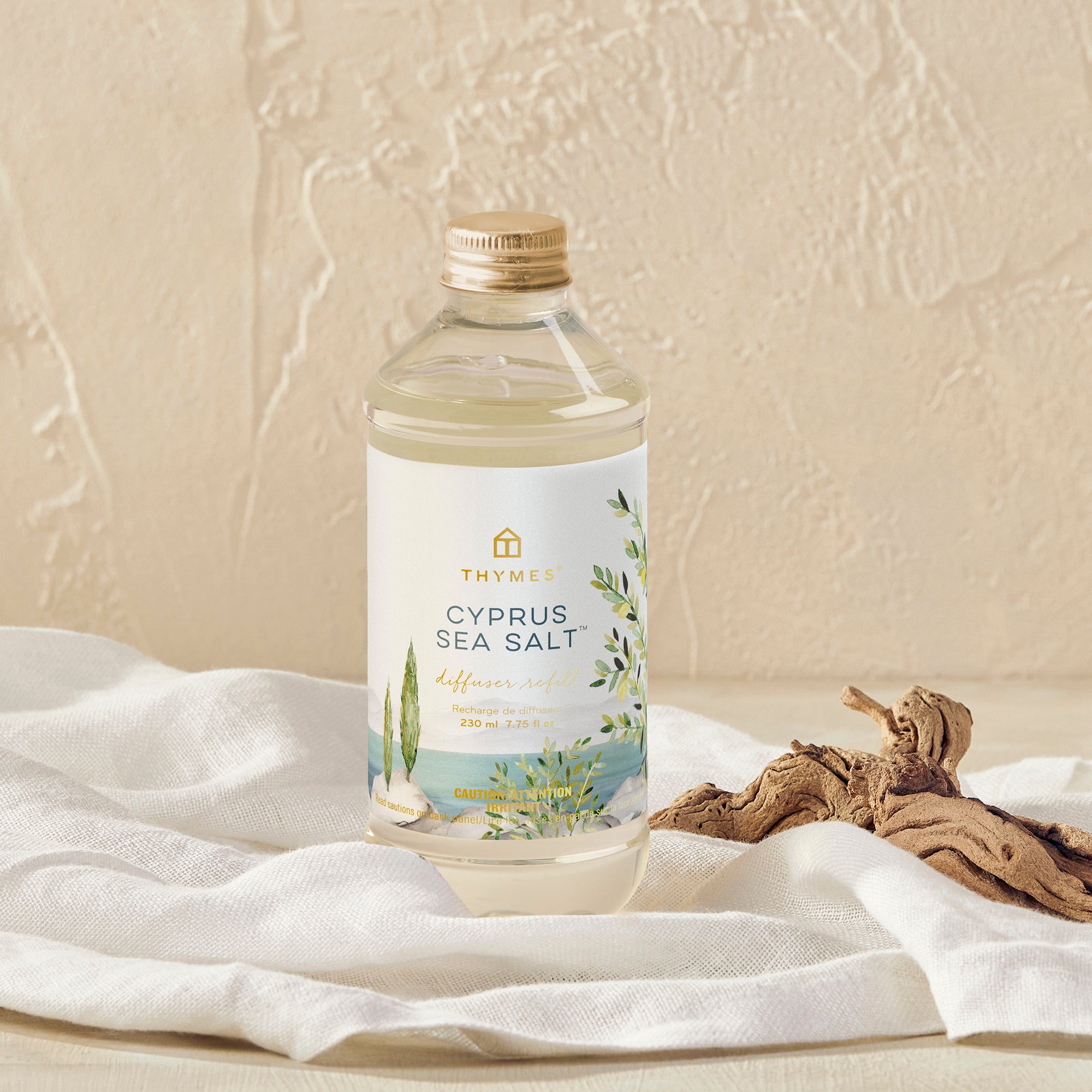 Bottle of Cyprus Sea Salt on a textured surface with a white cloth and driftwood.