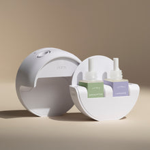White diffuser with eucalyptus and lavender essential oil bottles on a beige background