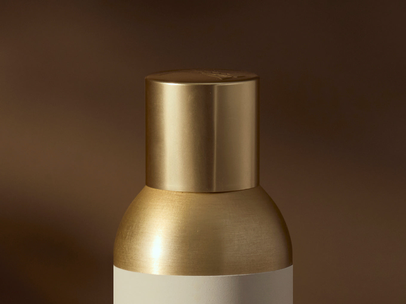 Gold-colored lampshade on a dark brown background