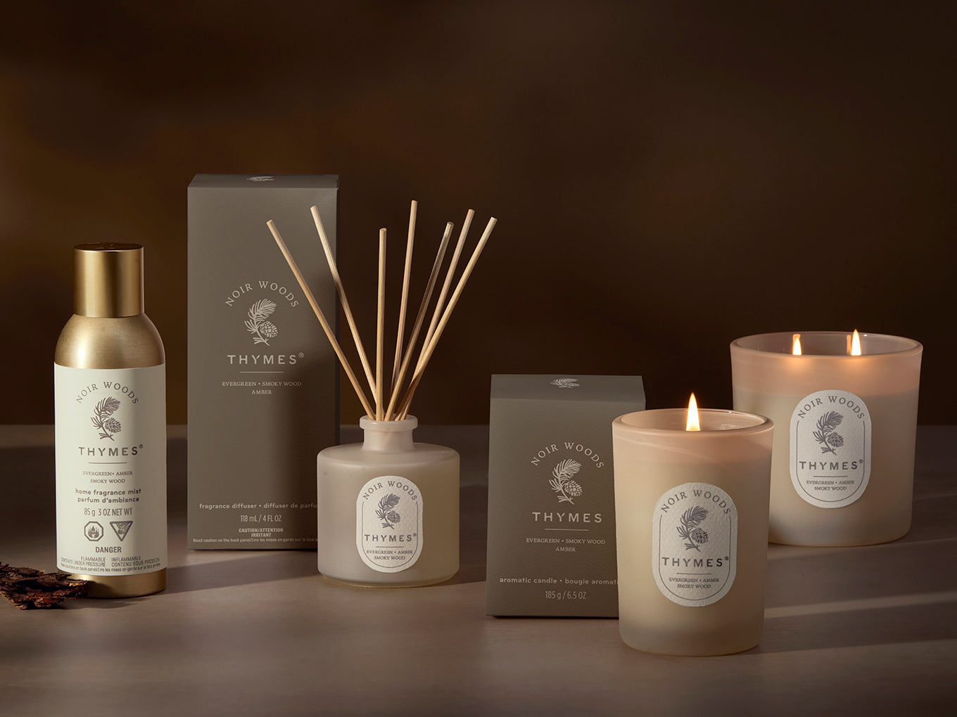 Thymes product line including candles, diffuser, and bottle on a dark background
