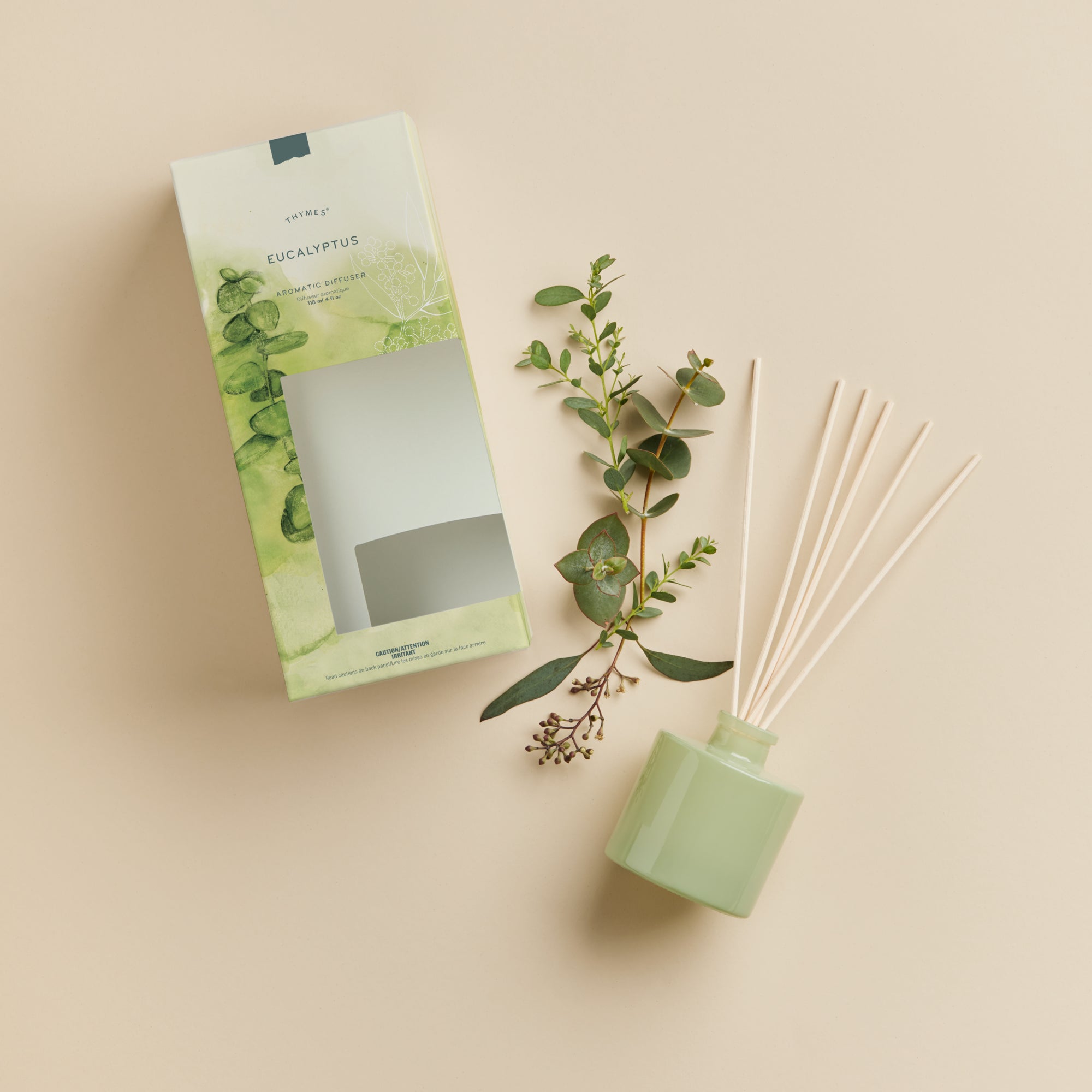 Green eucalyptus diffuser with packaging on a beige background