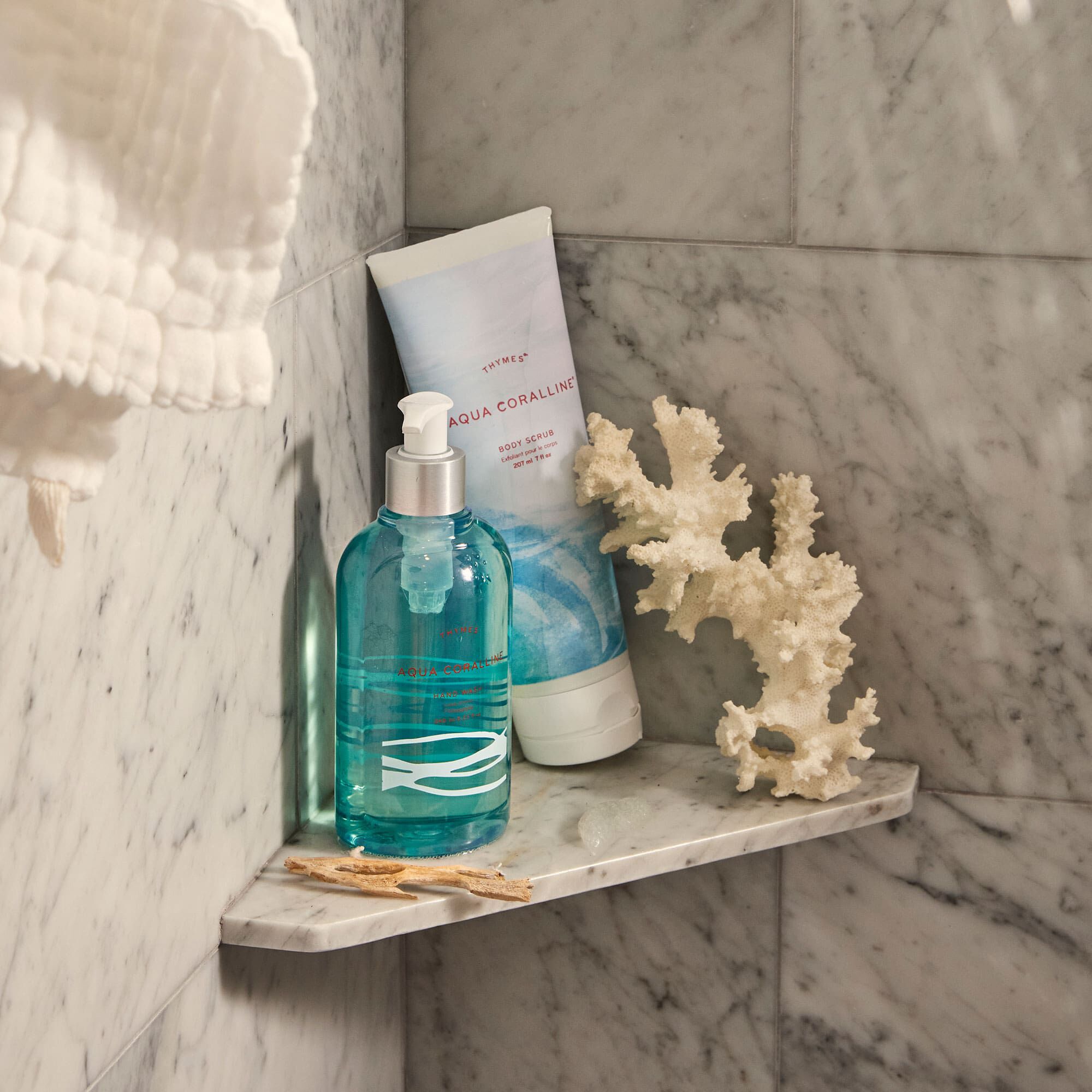 Thymes Aqua Coralline Body Scrub for exfoliation on shower shelf with Thymes Aqua Coralline Hand Wash