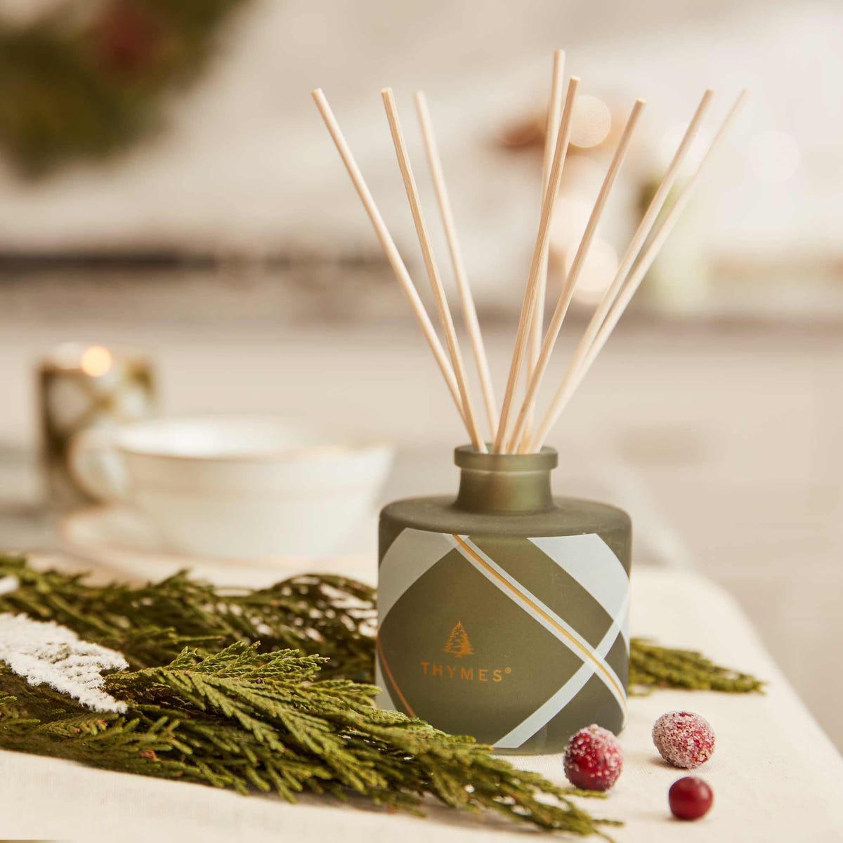 Alternate image of Thymes Frasier Fir Frosted Plaid Petite Reed Diffuser in use on table