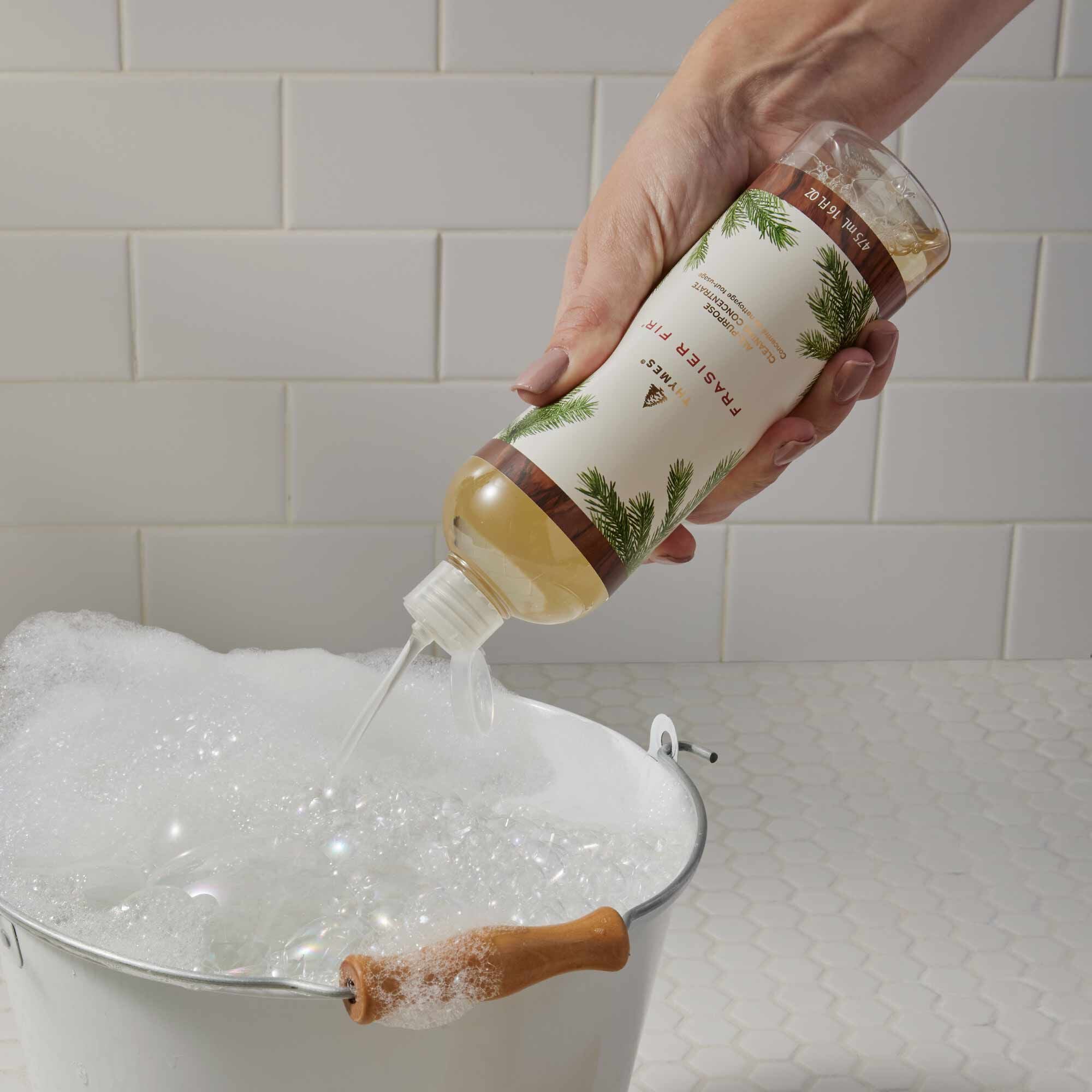 Squeezing Bottle of Thymes Frasier Fir All-Purpose Cleaning Concentrate into Bucket