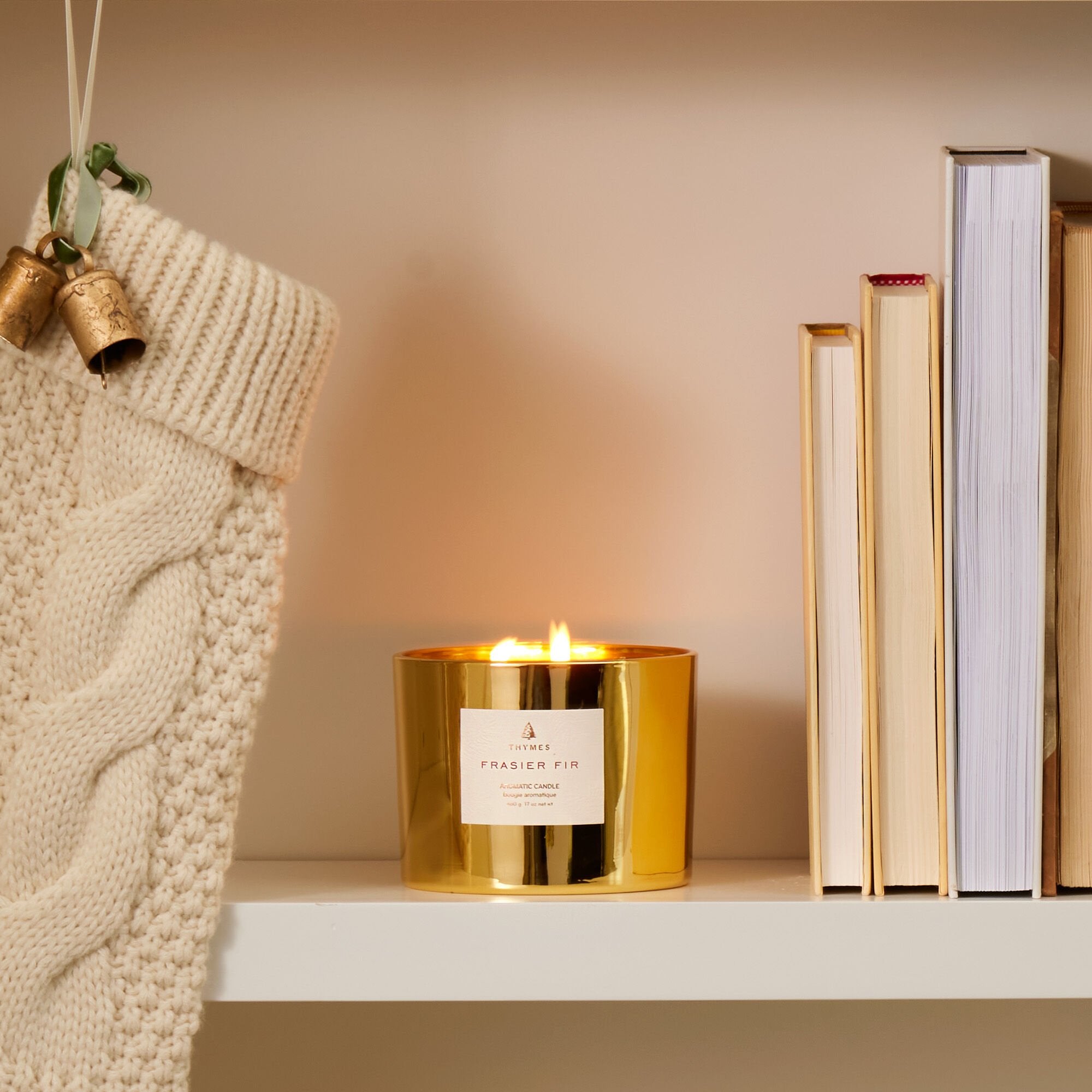 Frasier Fir Gold 3-Wick Candle Lit on Bookshelf