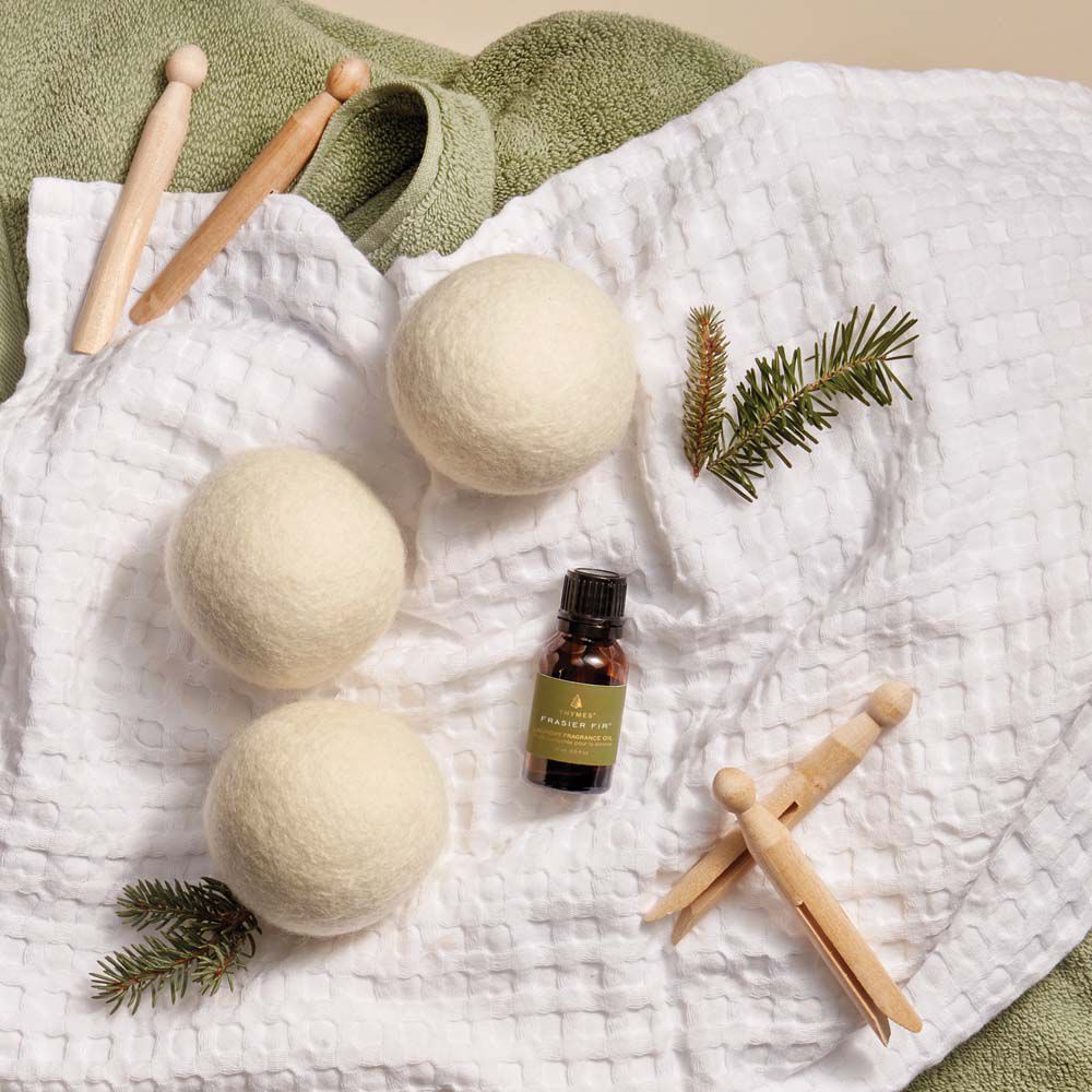 Frasier Fir Wool Dryer Balls & Laundry Fragrance Oil flat lay on towels with clothes pins