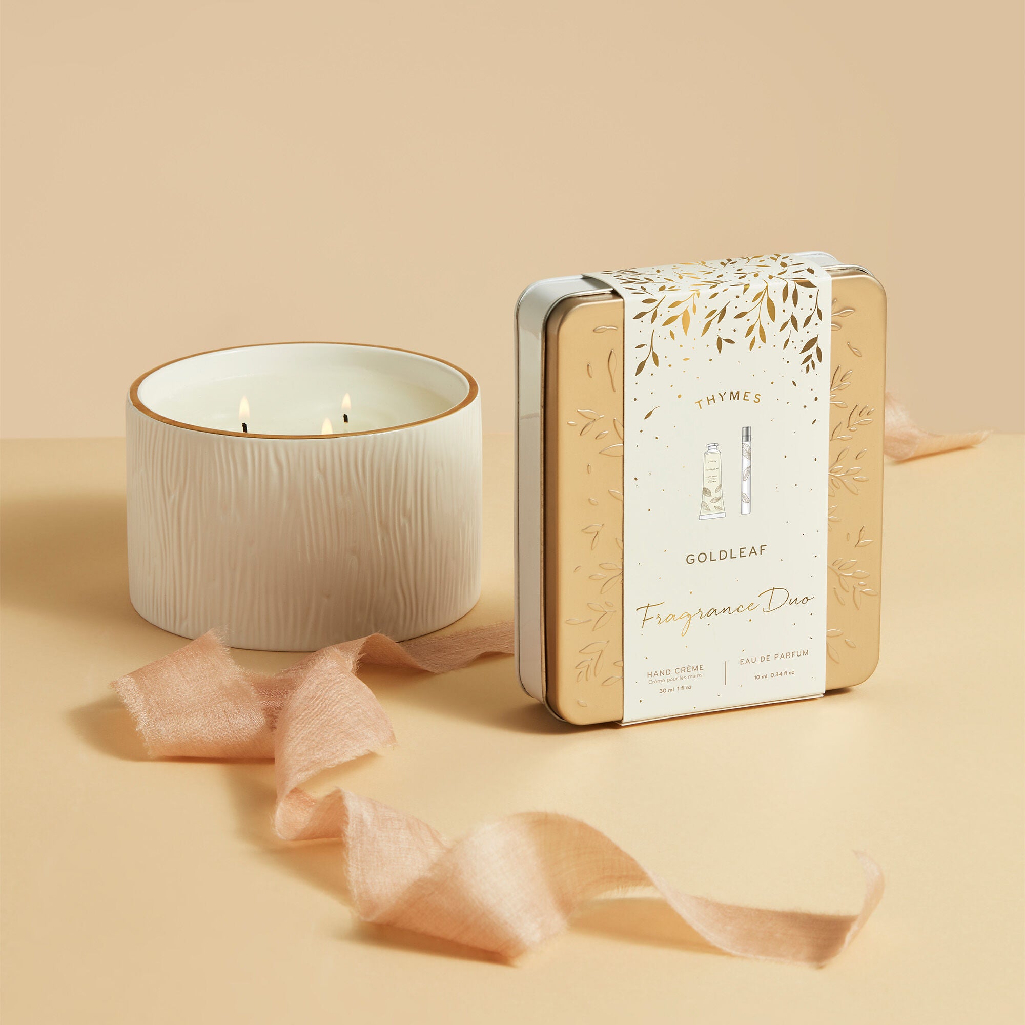 Thymes Goldleaf Fragrance Duo in Package Beside White Candle