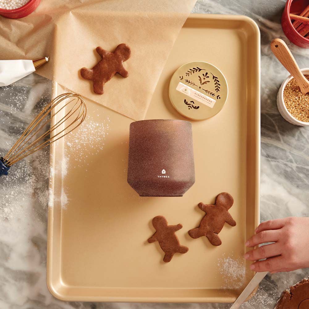 Thymes Gingerbread Large Candle is a Holiday Fragrance on gold cooking tray with Gingerbread man cookies