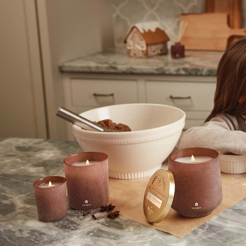 Thymes Gingerbread Large Candle is a Holiday Fragrance next to mixing bowl and Gingerbread Candles on kitchen countertop